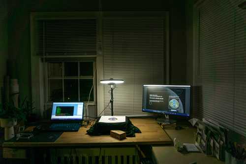 Image of prototype station from afar, with both a laptop and a secondary display visible and running the Moonshot software. The camera rig sits in between the two displays on the desk.