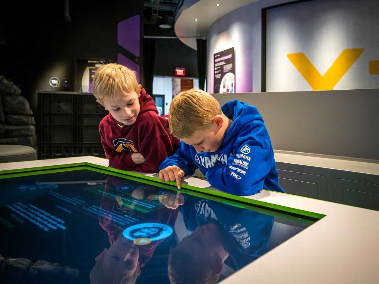 Two children using a touch-interactive table in the Moonshot Museum.