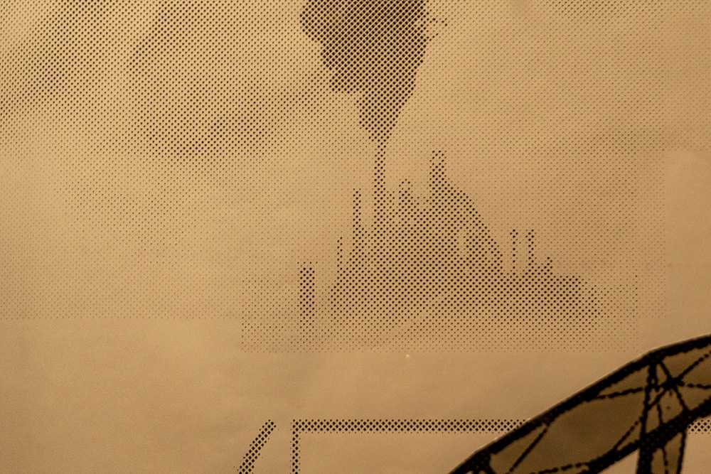 Picture of wallpaper, printed with the image of smokey clouds, some of them emerging from the faint silhouette of a smokestack emerging from several others in a little mound in the distance.